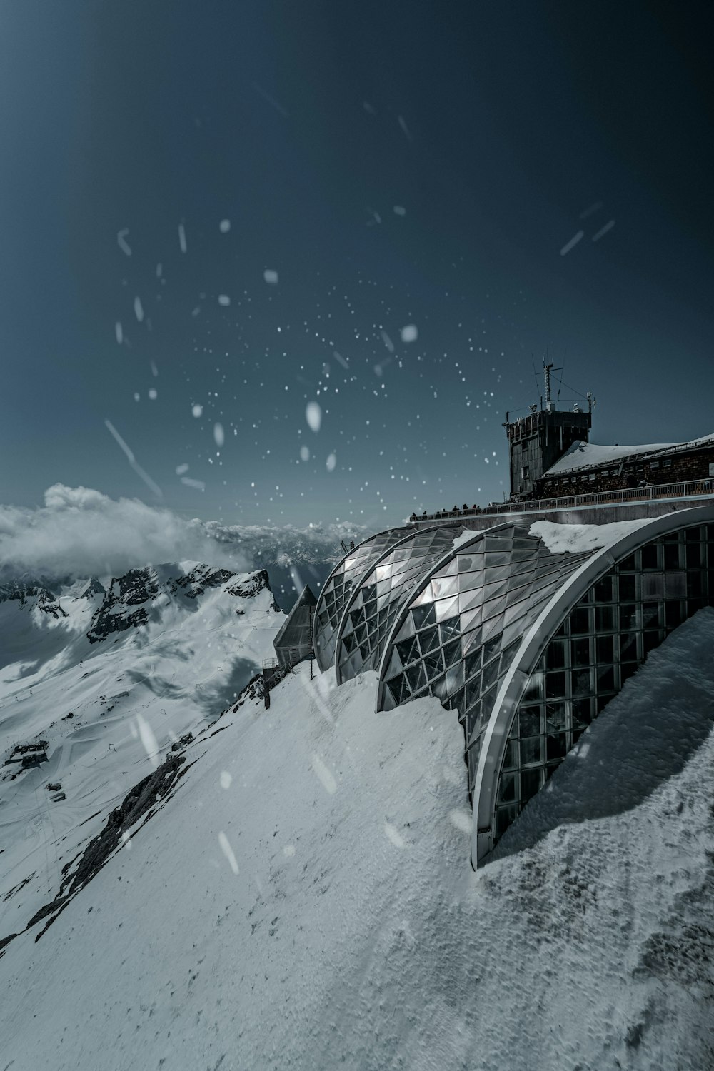 a snow covered mountain with a building on top of it