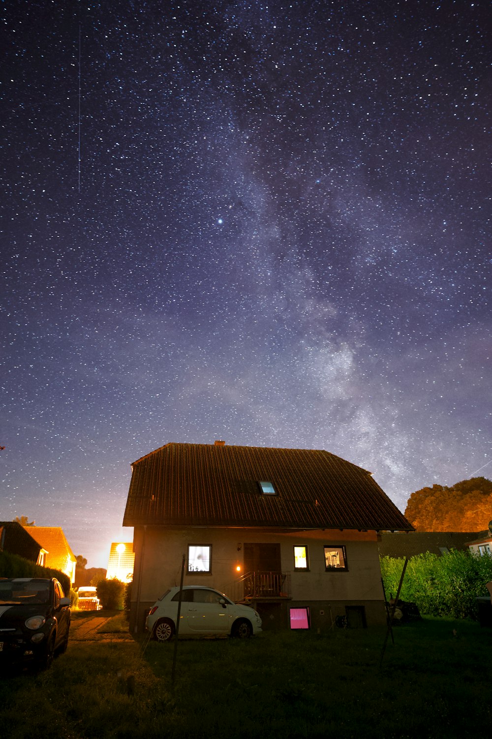 a house with a car parked in front of it under the stars