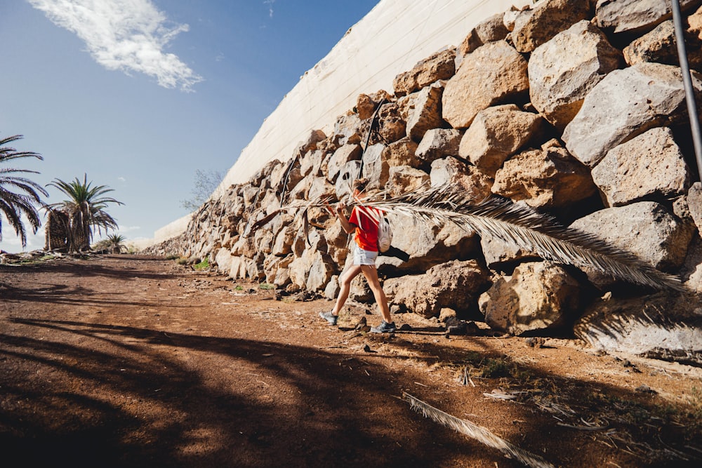 a man climbing up the side of a stone wall