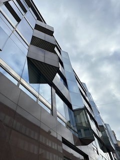 An architectural shot of a modern building against a cloudy sky.
