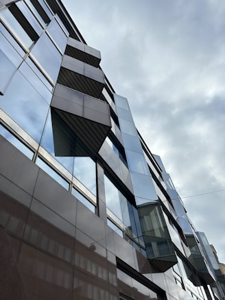 An architectural shot of a modern building against a cloudy sky.