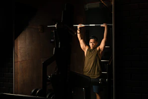 A focused athlete lifting heavy weights in a sleek gym setting under dramatic lighting.