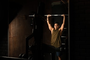 A personal trainer guiding a client through a strength training exercise in a bright gym