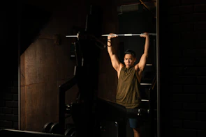 Personal trainer guiding a client through strength exercises in a bright gym space.