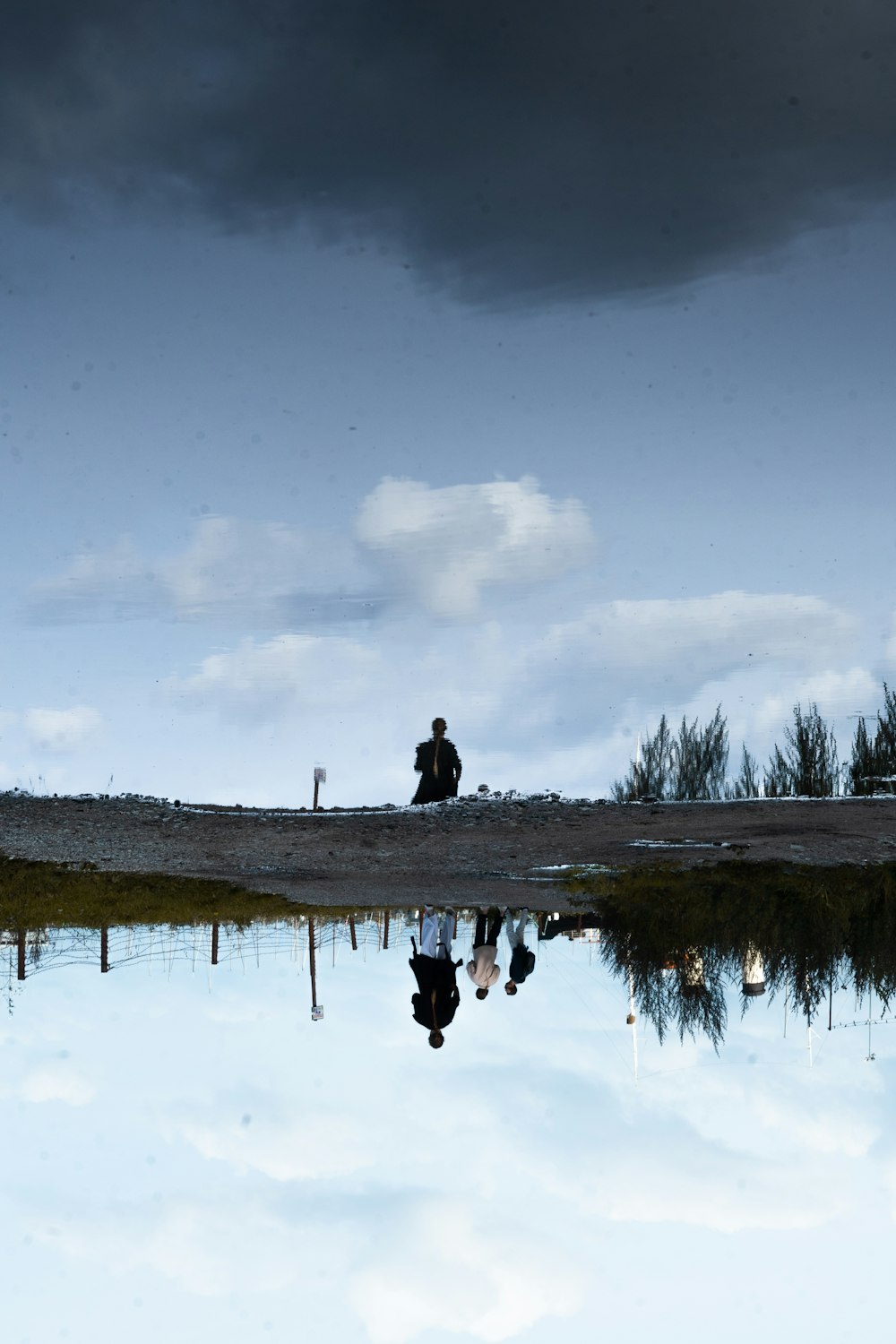 a man standing on a beach next to a body of water