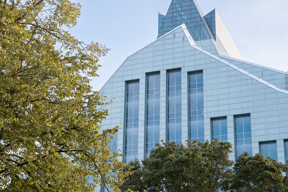 a tall building with many windows and trees in front of it