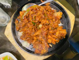 A sizzling stir-fry dish with bright vegetables and tender meat on a dark plate.
