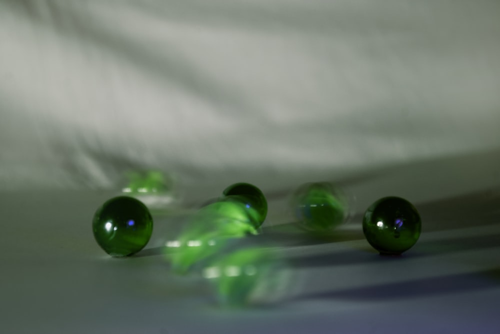 un groupe de boules de verre vertes assises sur une table