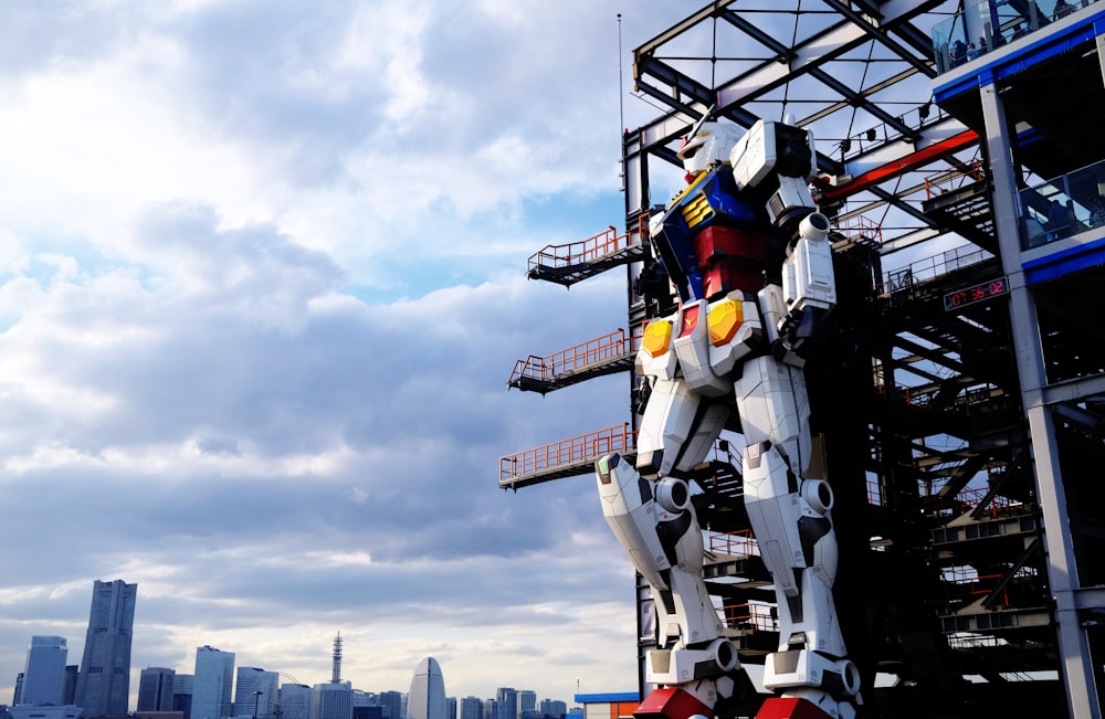 a statue of a giant robot standing in front of a city