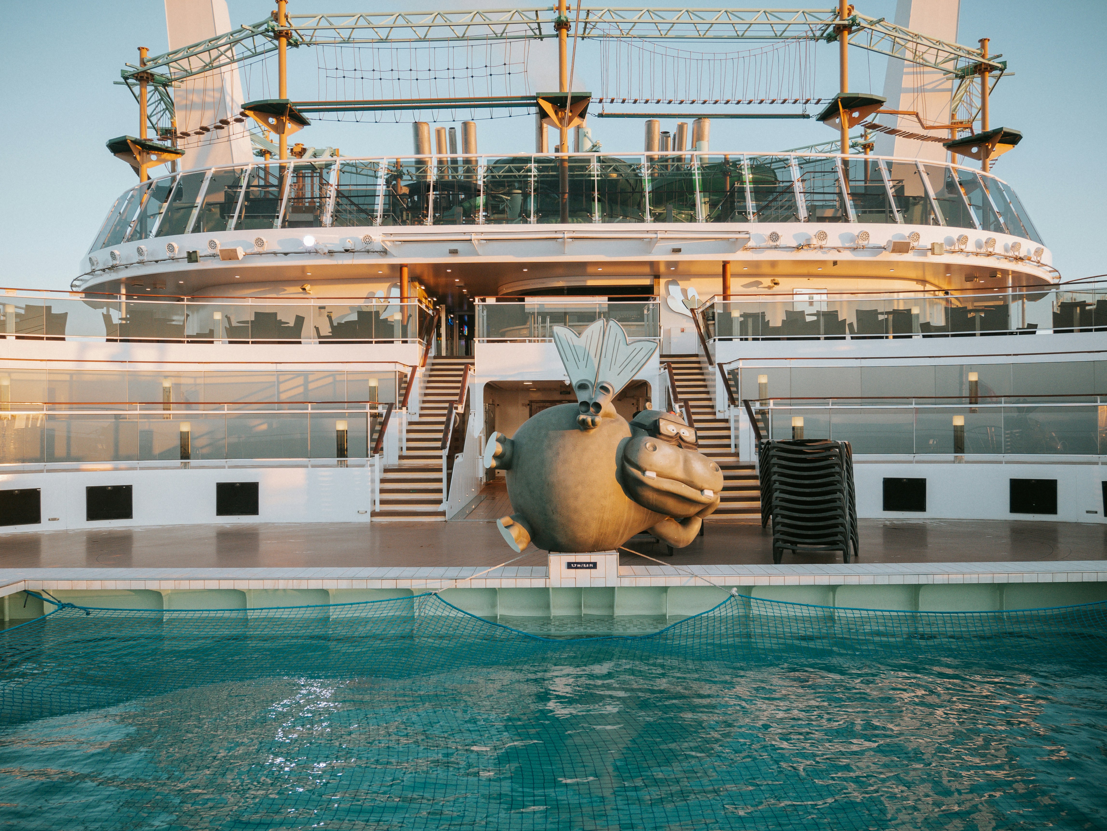 a statue of a fish in front of a cruise ship, 
