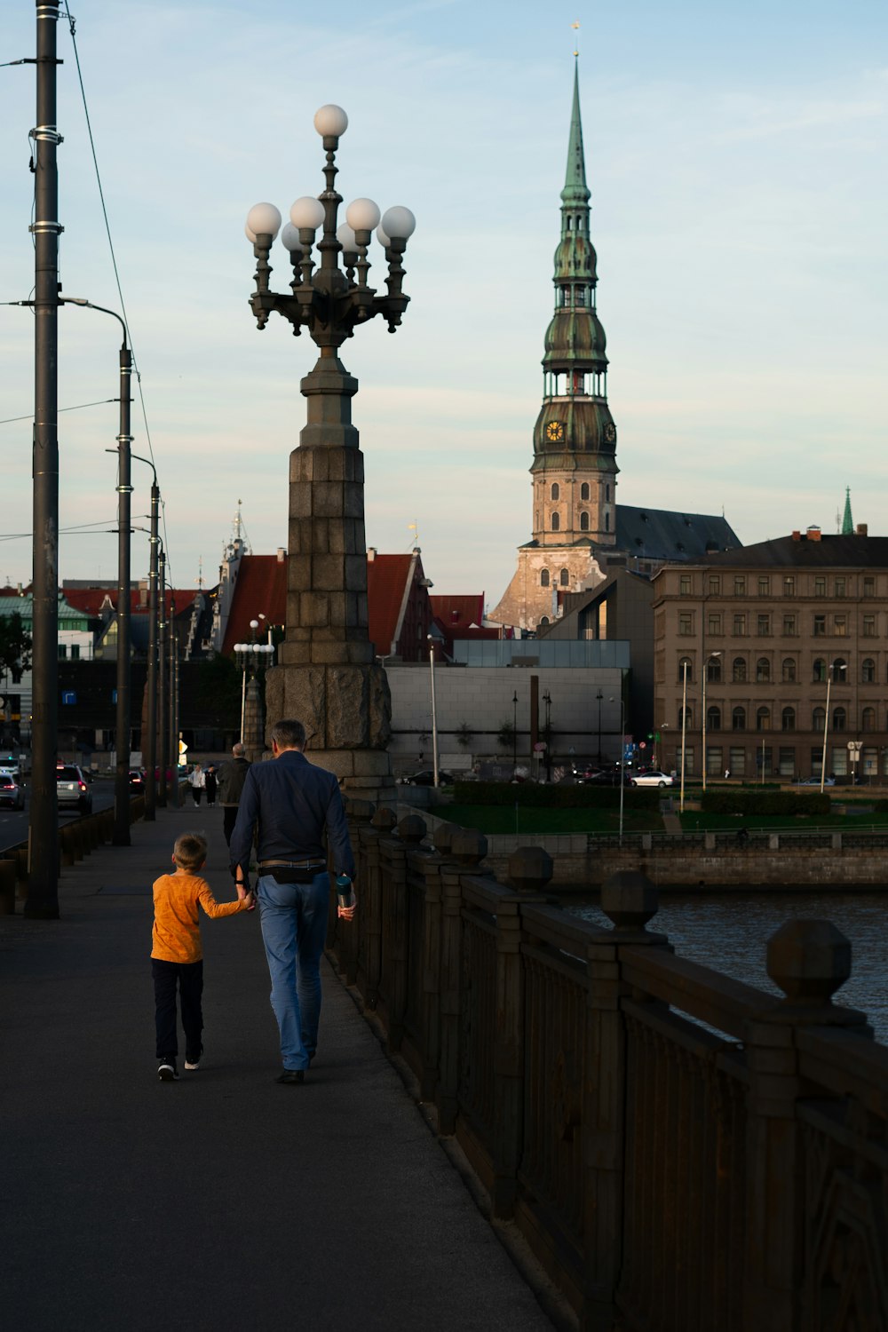 a man and a child walking on a bridge