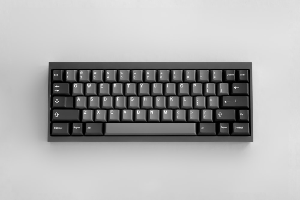 Eine schwarze Tastatur sitzt auf einem weißen Tisch