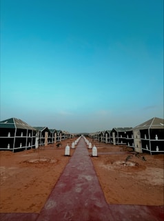 Pathway lined with lanterns leading to the cozy glamping tents at dusk.