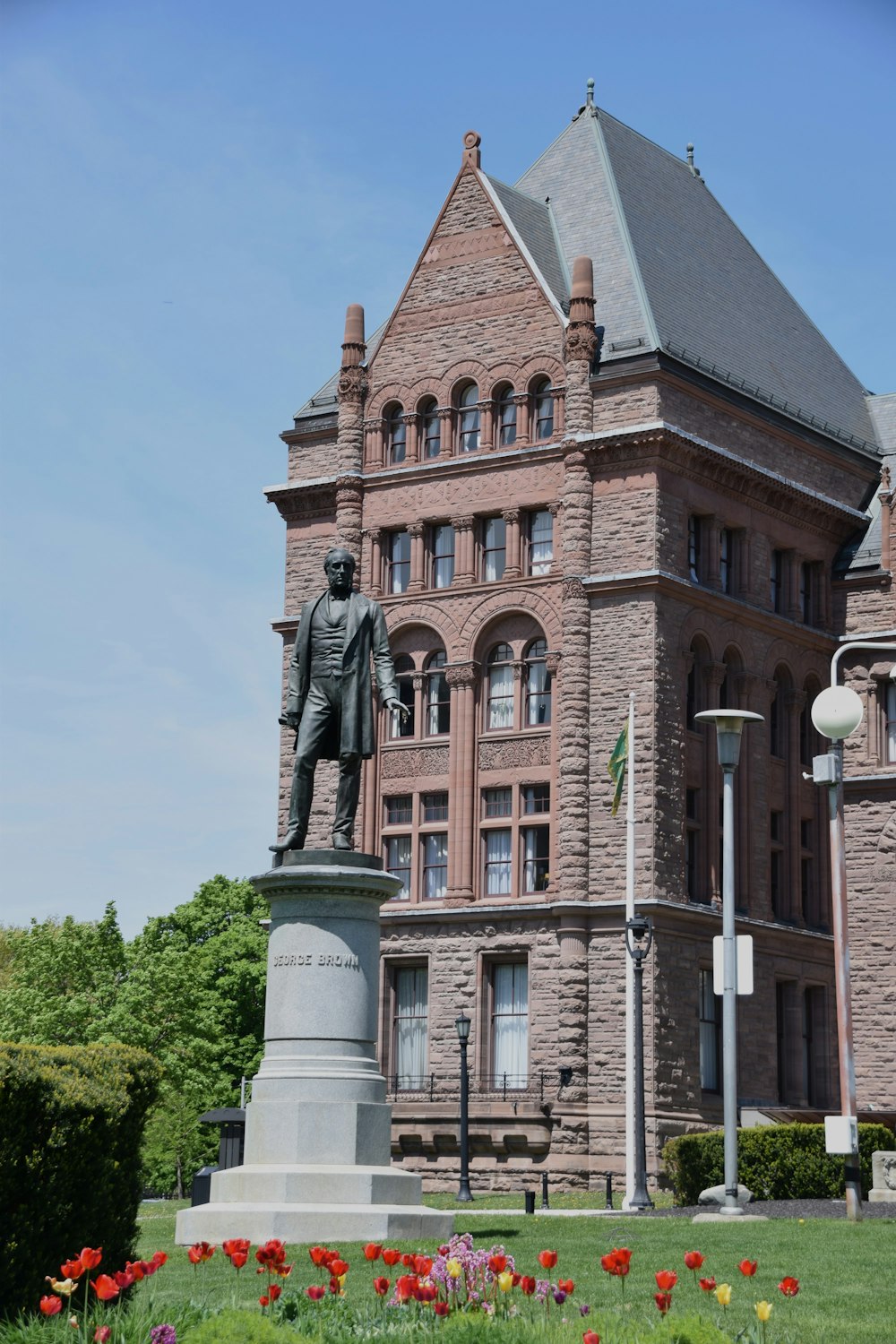 a large brick building with a statue in front of it