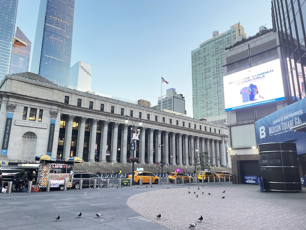 a group of birds sitting on the ground in front of a building