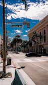 A sunny street in Bel Air, California, with a classic 'For Sale' sign featuring belairre.com prominently displayed.