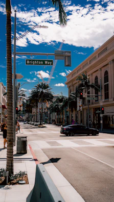 A sunny street in Bel Air, California, with a classic 'For Sale' sign featuring belairre.com prominently displayed.