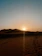 A warm golden sunset over the Agafay desert with a silhouette of a camel caravan.