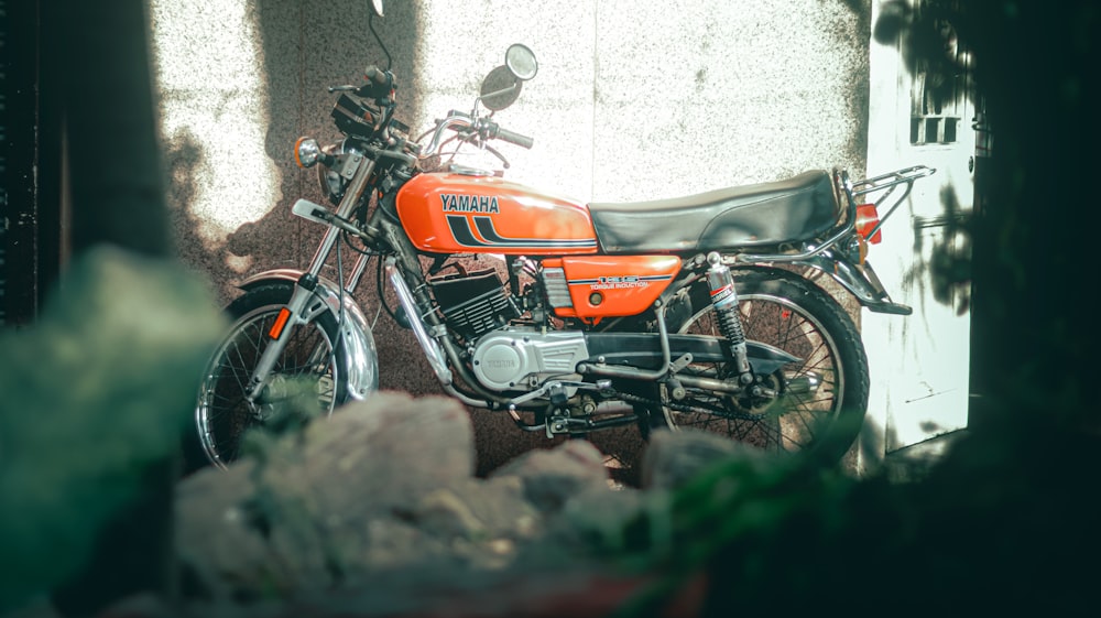 an orange motorcycle parked in front of a building