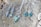 A collection of silver jewelry, including a pair of earrings and a necklace with geometric designs and green stones, is displayed on a textured wooden surface.
