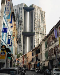 Modern 5-story shoptown buildings lining a bustling riverside boulevard with vibrant storefronts.