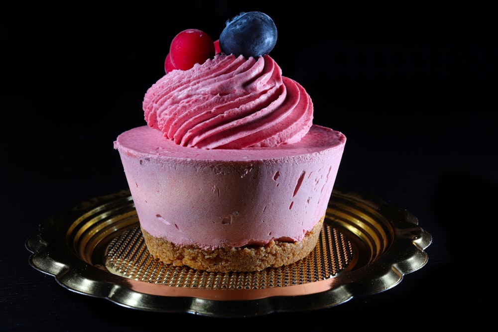 a cupcake with pink frosting and cherries on top