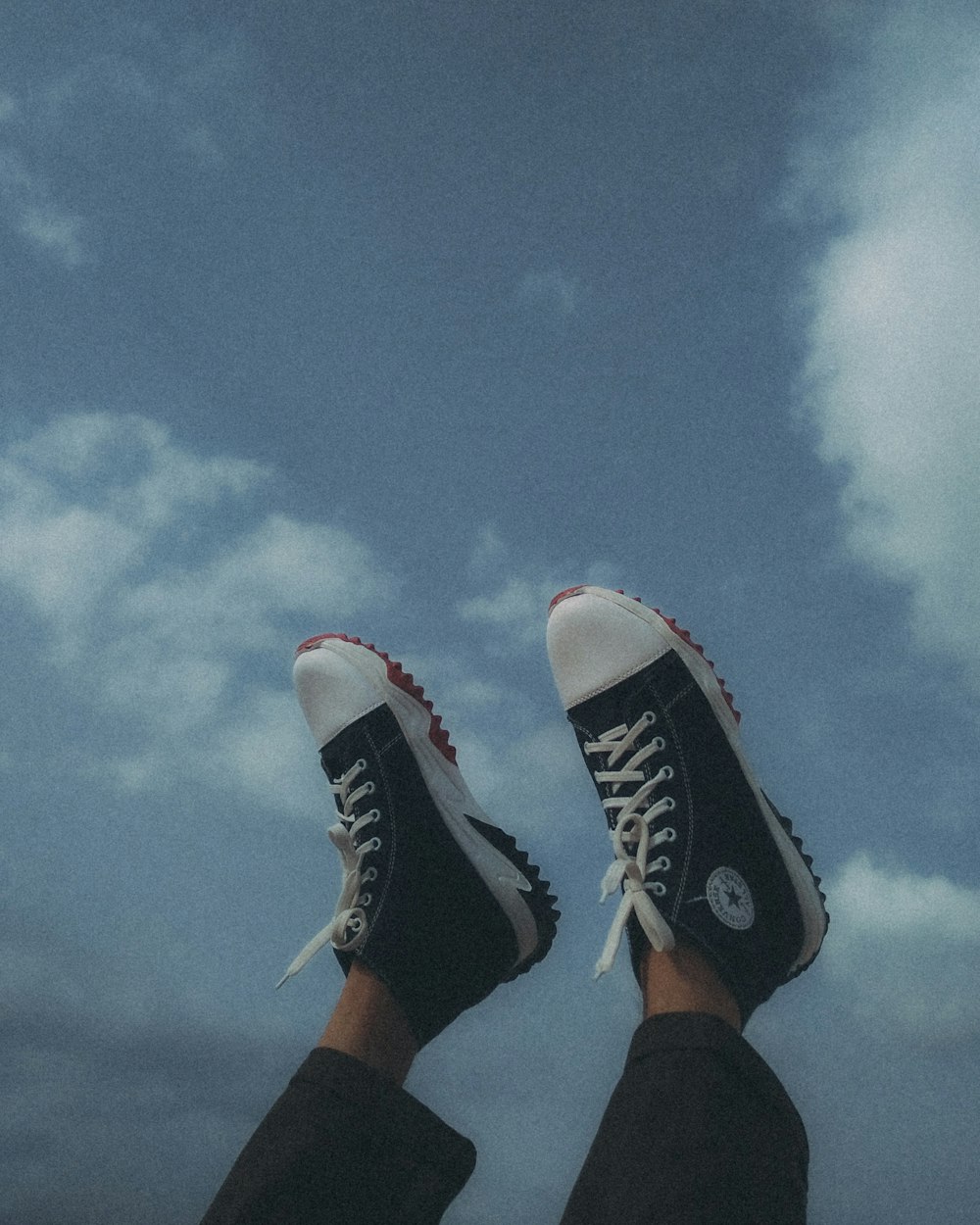 a person's feet in black and white sneakers