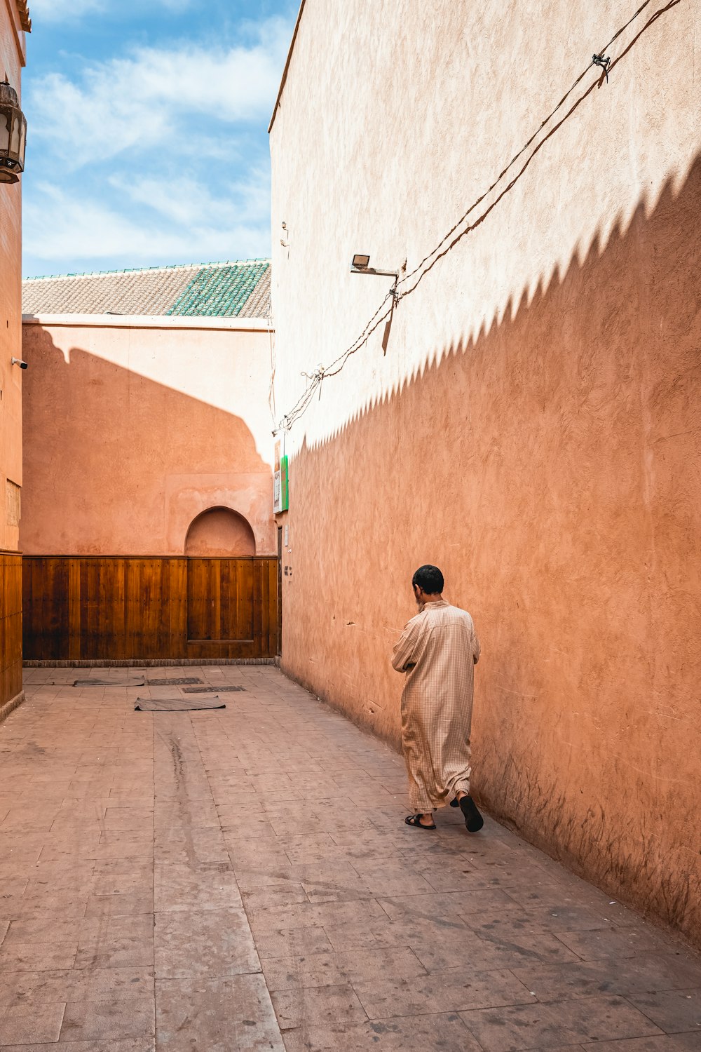 a man walking down a street next to a building