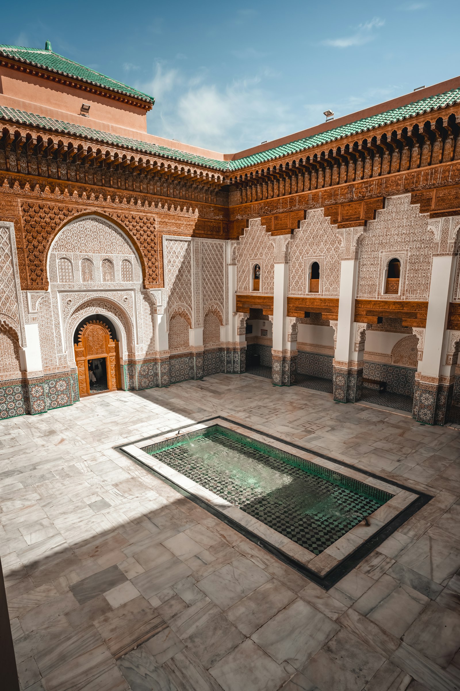 Patio of a traditional Marrakech riad with marble fountain and zellige tiles