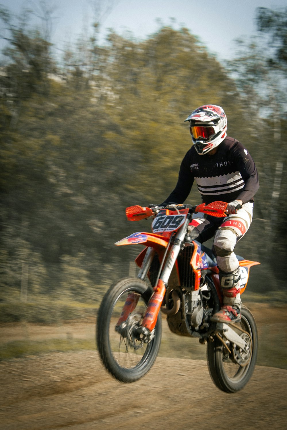 a man riding a dirt bike on a dirt road