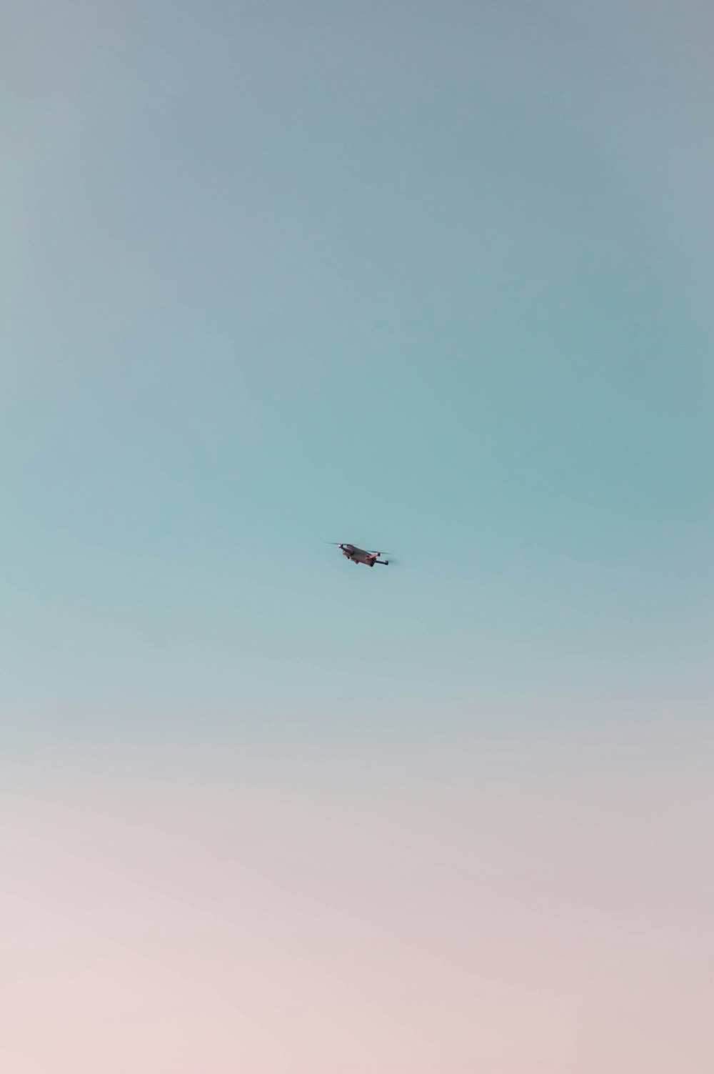 an airplane flying in the sky with a blue sky background