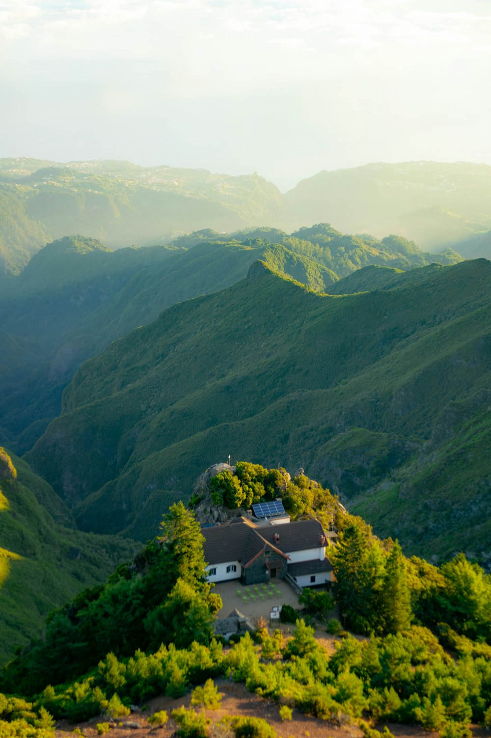 a house on top of a hill with mountains in the background