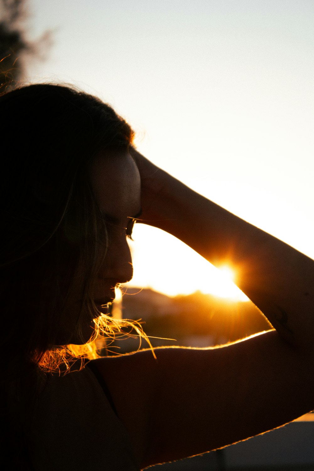 a woman holding her hair in the wind