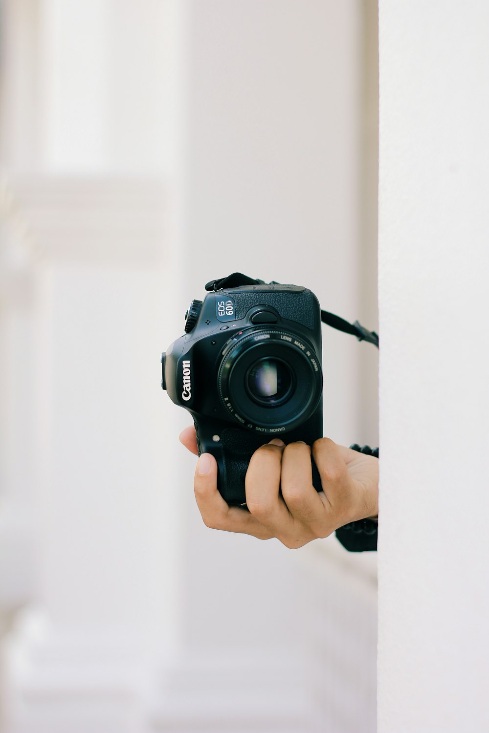 a person holding a camera up against a wall