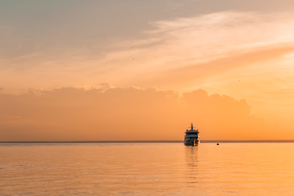 a boat is out on the water at sunset