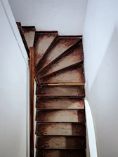 Historic staircase leading up to the attic apartment, with warm wooden steps and handrails.