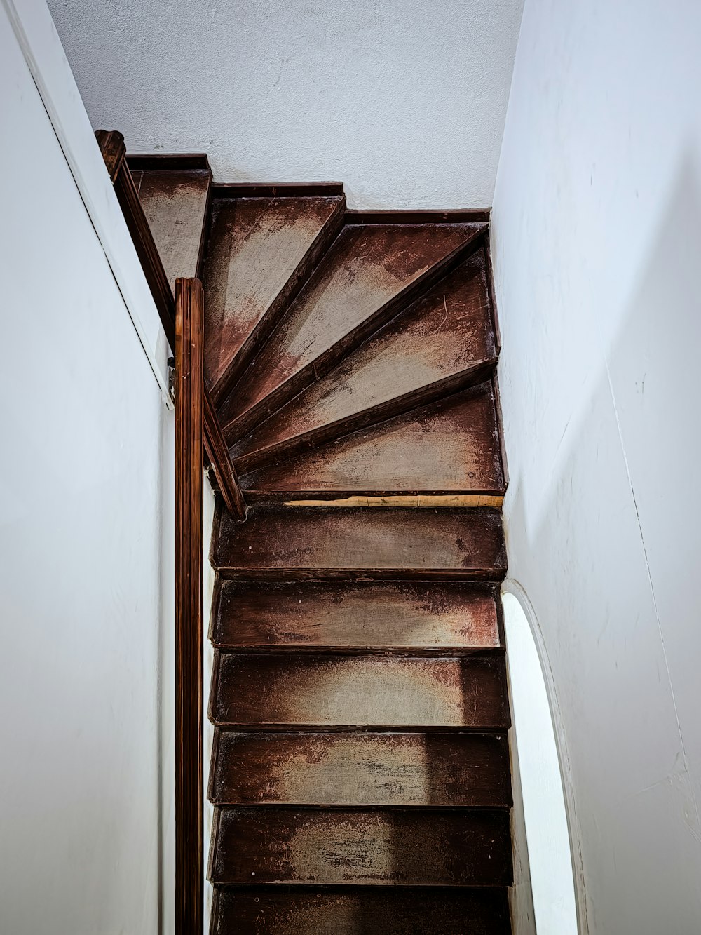 a wooden stair case in a white wall