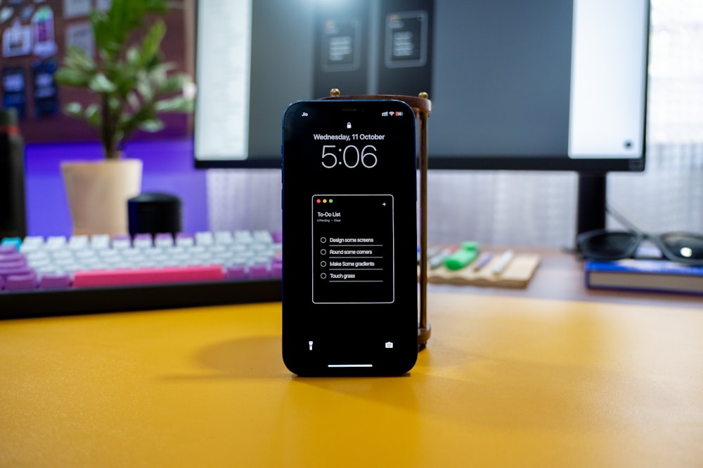 a cell phone sitting on a desk next to a keyboard