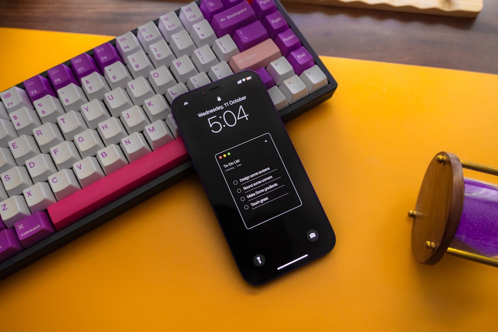 a cell phone sitting next to a computer keyboard