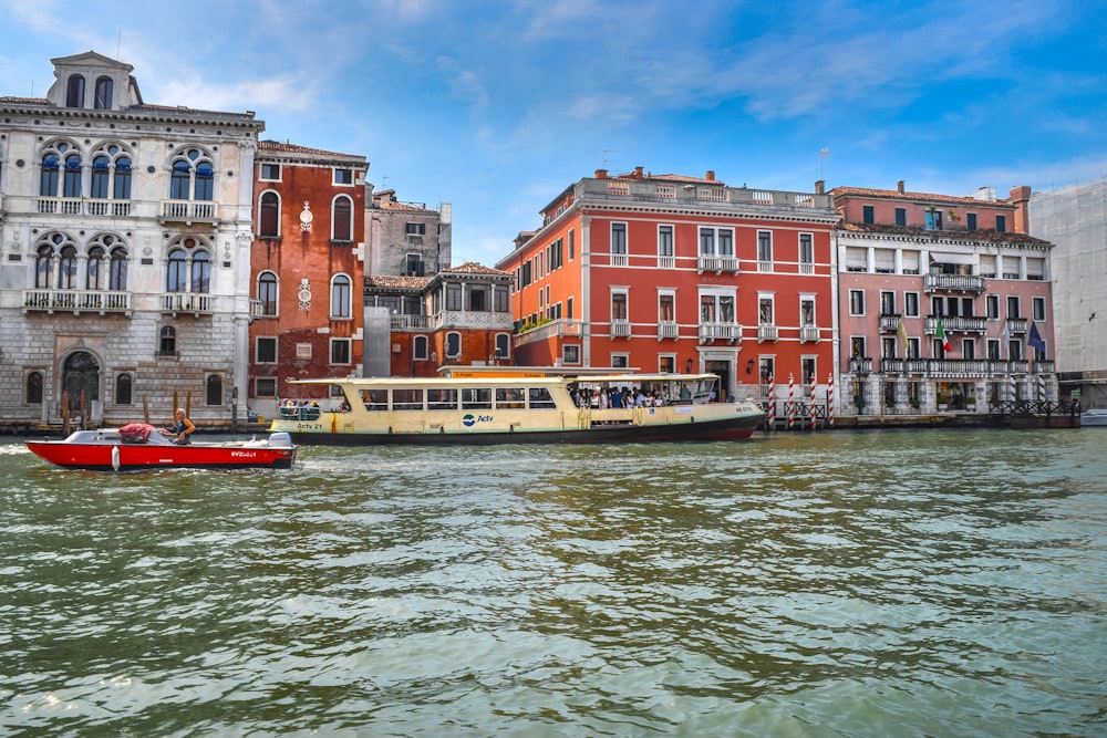 a boat traveling down a river next to tall buildings