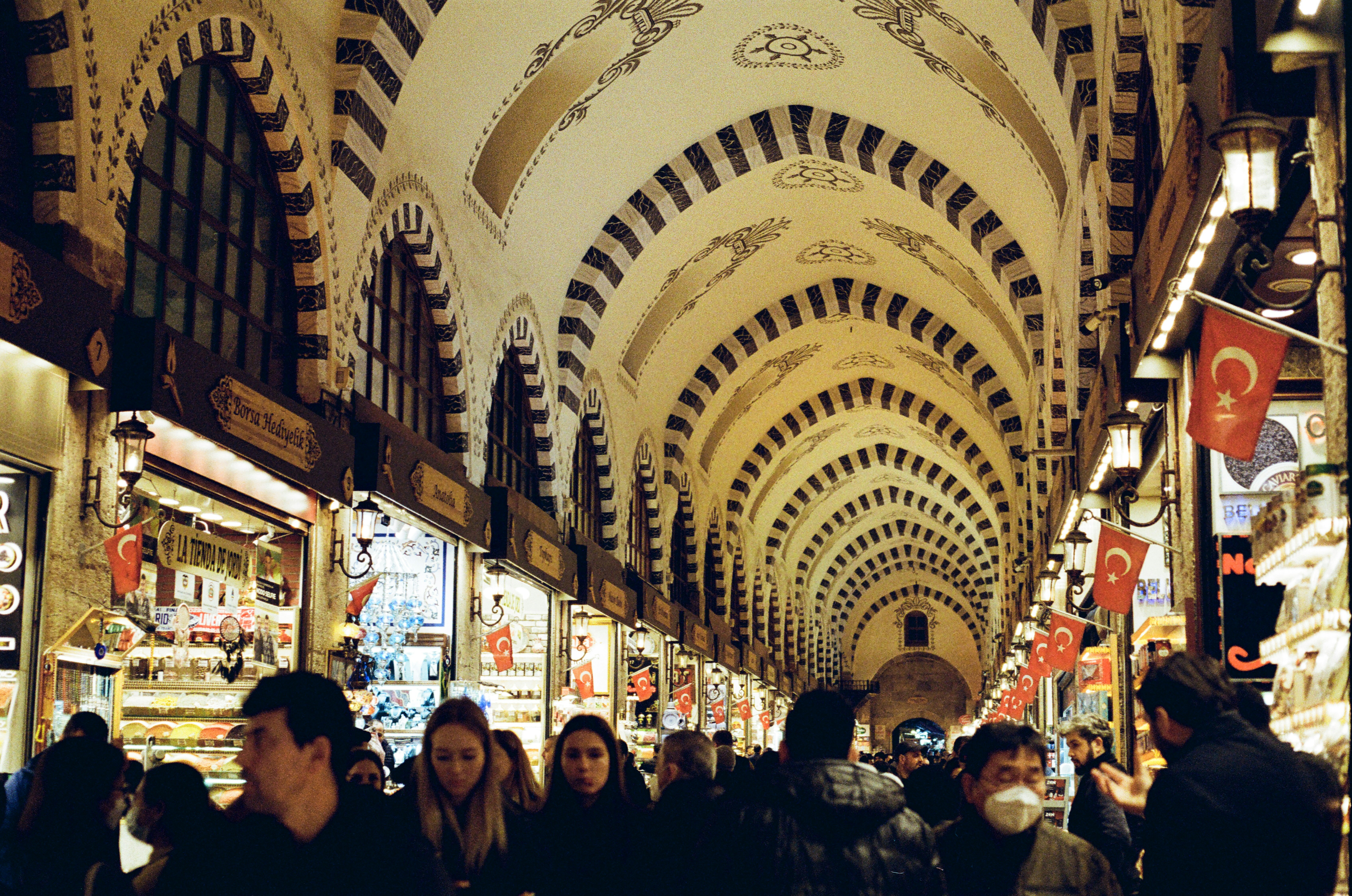 a group of people walking through a shopping mall, 