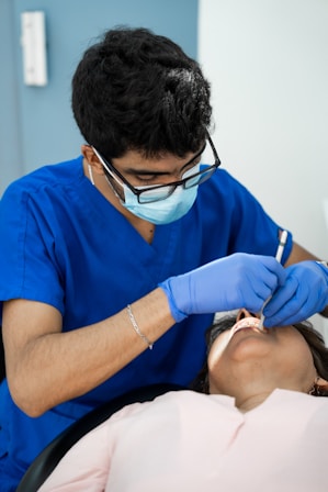 a man in a blue shirt is getting his teeth checked