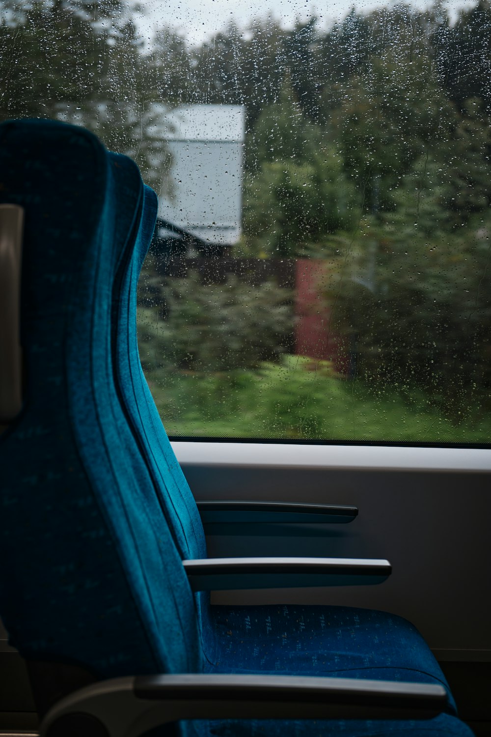 Ein blauer Stuhl sitzt vor einem Fenster
