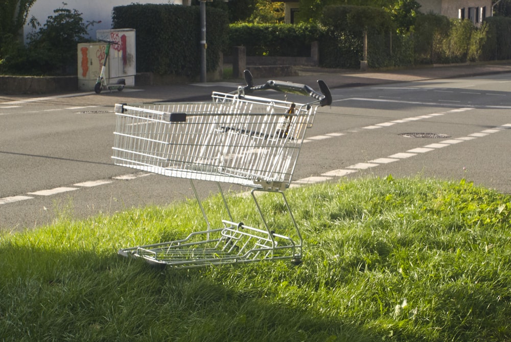 a shopping cart sitting on the side of a road