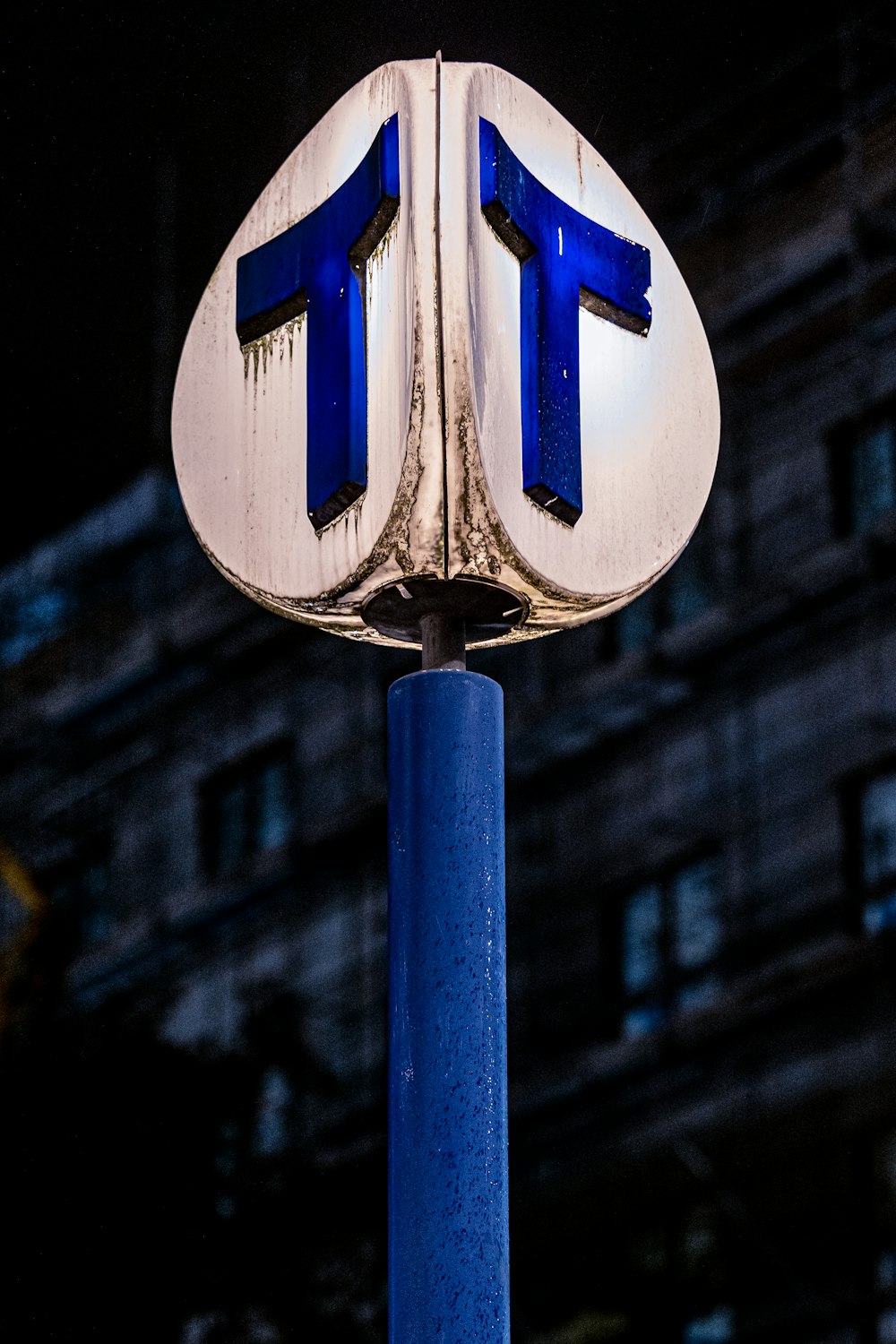 um close up de uma placa de rua com um edifício ao fundo