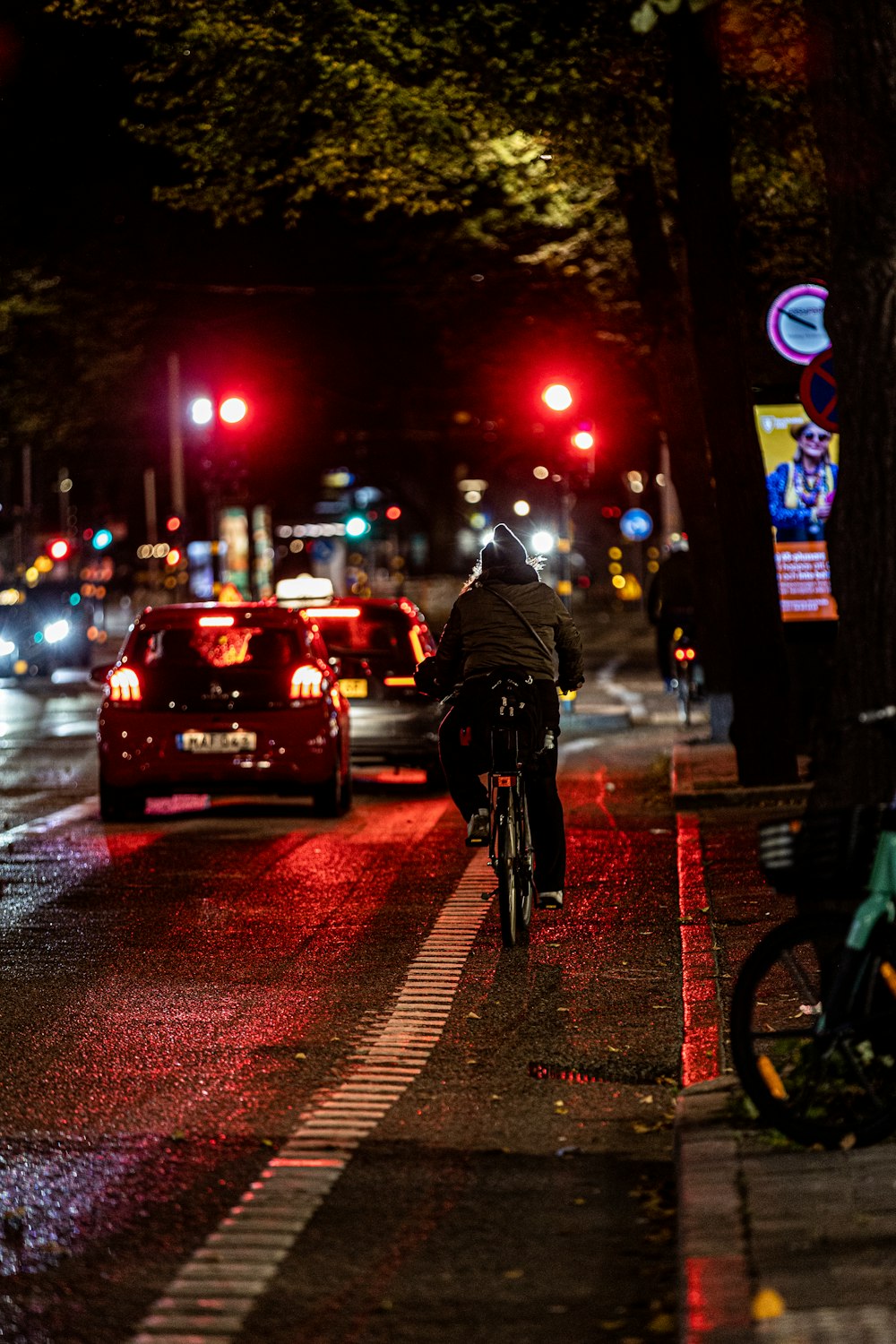 a person riding a bike down a street at night