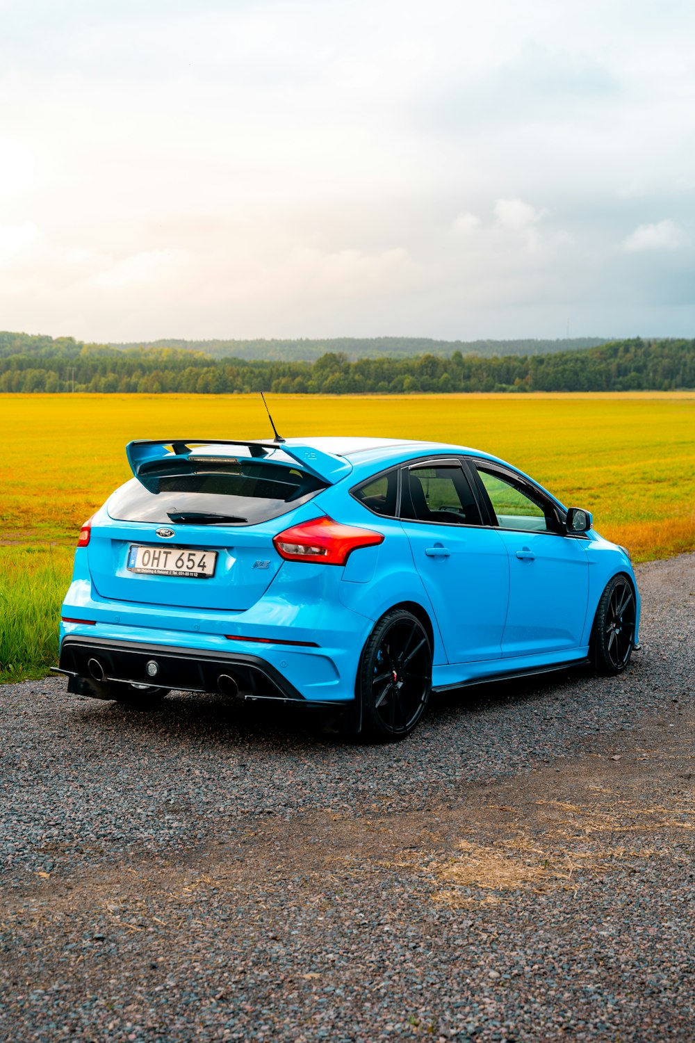 a blue car parked on the side of a road