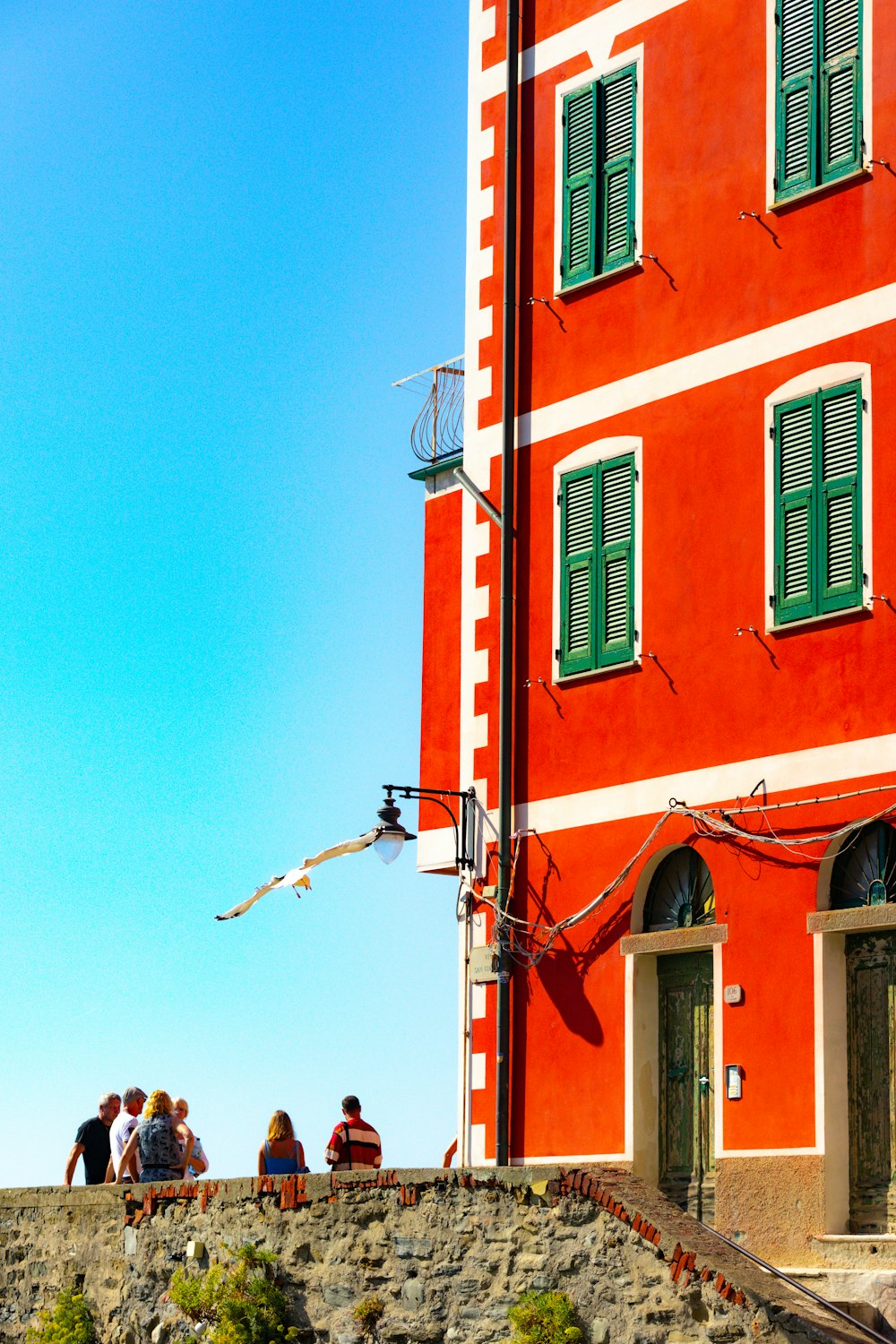 a group of people sitting outside of a red building