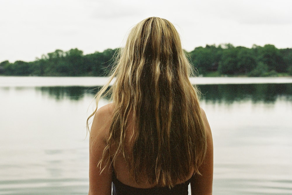 a woman standing in front of a body of water