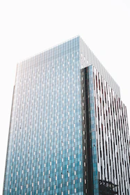 Close-up of a modern building facade with blue and green accents reflecting the brand colors.